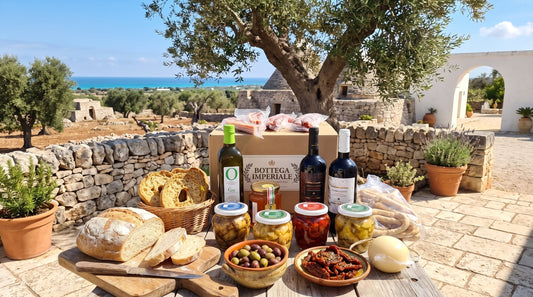 Prodotti tipici pugliesi su tavola in pietra: olio, scaldatelli, salumi formaggi e conserve